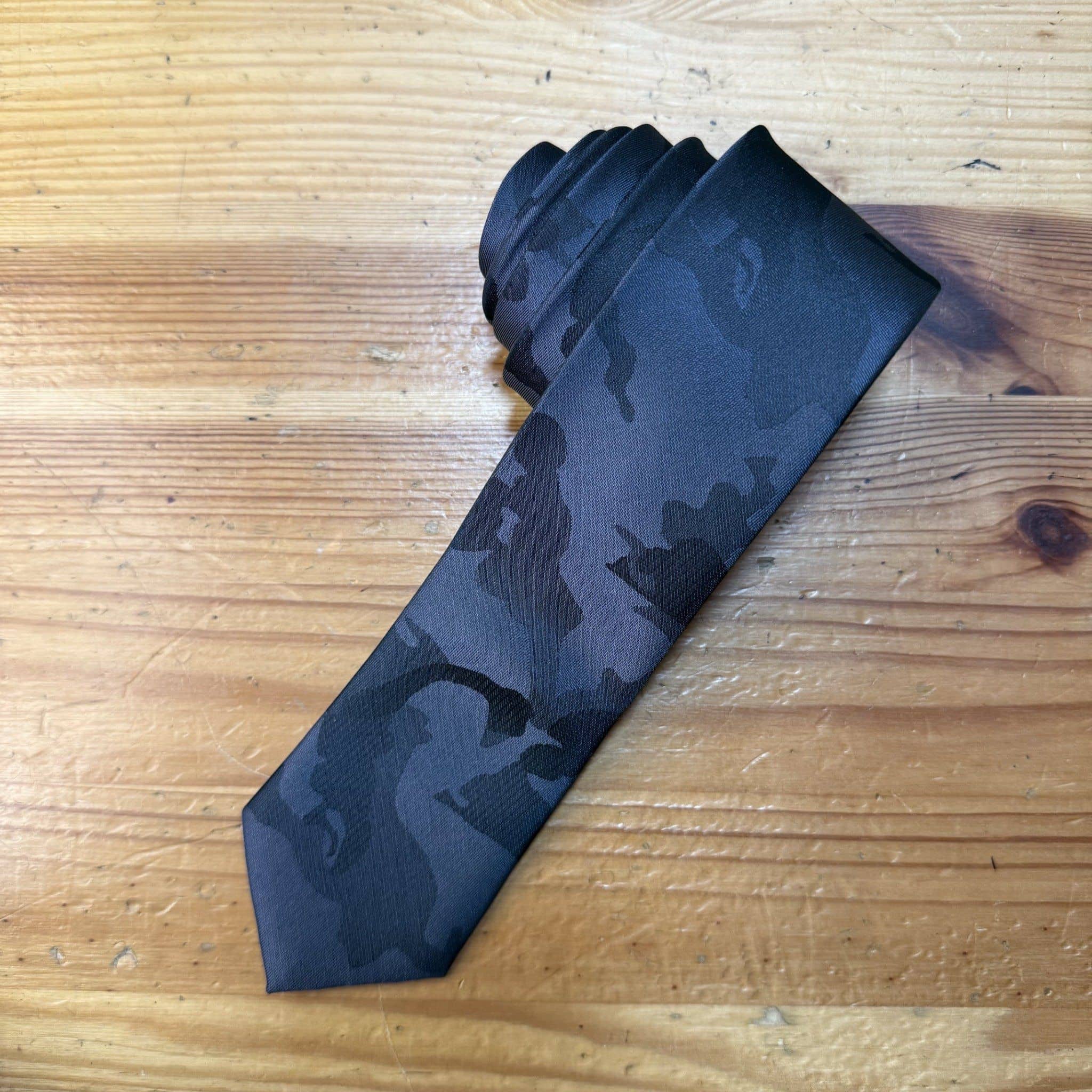 Corbata negra con patrón camuflaje para hombre, accesorio elegante para ocasiones formales.