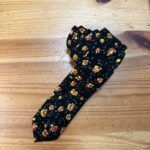 2. Accesorios de moda para mujer con estampado floral en tonos amarillos y verdes sobre fondo negro.