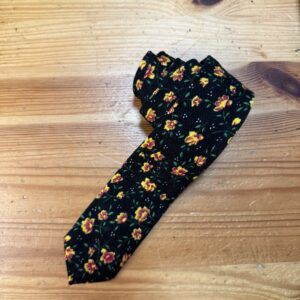 2. Accesorios de moda para mujer con estampado floral en tonos amarillos y verdes sobre fondo negro.