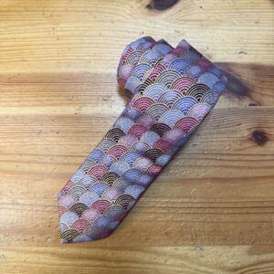 Elegante pajarita de tela con patrón de ondas en tonos metalizados y colores vibrantes.