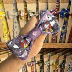 1. Diadema de tela con personajes de animación y rosas, colores vibrantes para accesorios divertidos.