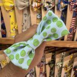 Lazo de tela con diseño de pelotas de tenis en tonos verdes y blancos.