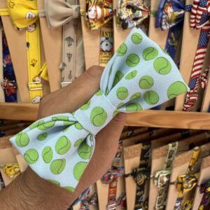 Lazo de tela con diseño de pelotas de tenis en tonos verdes y blancos.