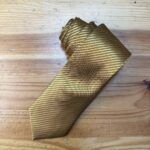 Corbata dorada con líneas finas perfecta para eventos formales o elegantes.