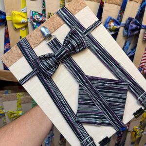Complemento para traje de niño, conjunto de pajarita y tirantes con rayas negras y lilas.
