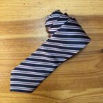 Corbata de seda a rayas azul marino y lila, ideal para ocasiones formales y elegantes.