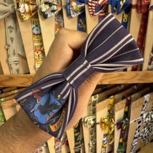 Pajarita de tela con diseño a rayas y estampado de superhéroes, perfecta para eventos y ocasiones especiales.