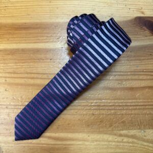 Corbata de seda con diseño a rayas en tonos morados y rosados, ideal para eventos formales y elegantes.