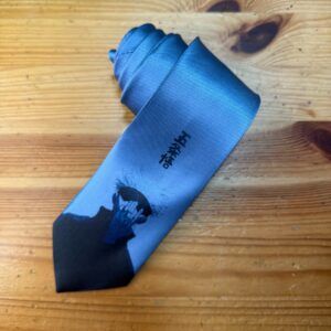 Corbata azul con diseño artístico y logo de Carmenatis, ideal para estilo elegante y moderno.
