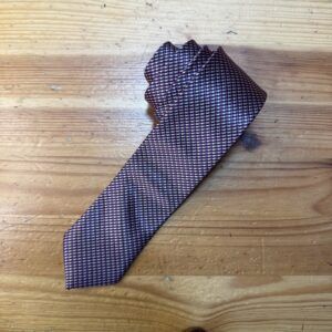 Corbata de seda de patrones pequeños en tonos morados y negros para accesorios elegantes.