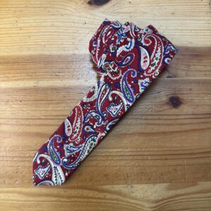 Banda de seda con estampado paisley en tonos rojo, azul y blanco, ideal para accesorios de moda y prendas elegantes.
