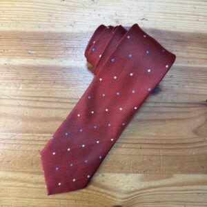 Corbata roja de seda con puntos blancos y azules para ocasiones formales y elegantes.