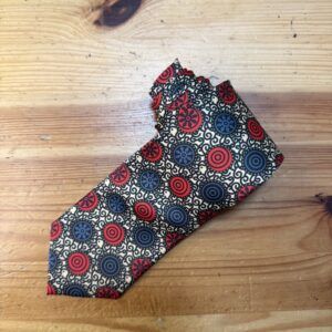 Sujeo de tela con estampado colorido de círculos y patrones en tonos rojo, azul y beige.