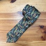 Corbata con diseño de selva tropical y felinos en tonos verdes y amarillos.