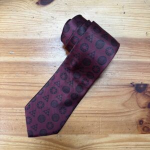 Corbata burdeos con logotipos de marcas de lujo, elegante y de diseño exclusivo.