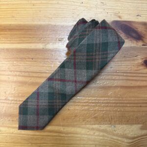 Corbata de lana con estampado de tartán en tonos verde, gris y rojo, ideal para looks clásicos y elegantes.