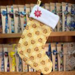 Calcetín navideño con estampado de leones y flores en tonos amarillos y naranjas.