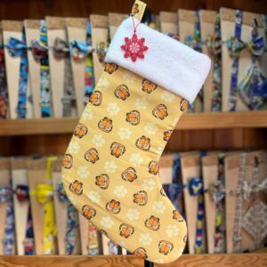Calcetín navideño con estampado de leones y flores en tonos amarillos y naranjas.