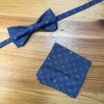 Corbata de charol azul con estampado de puntos y nudos.