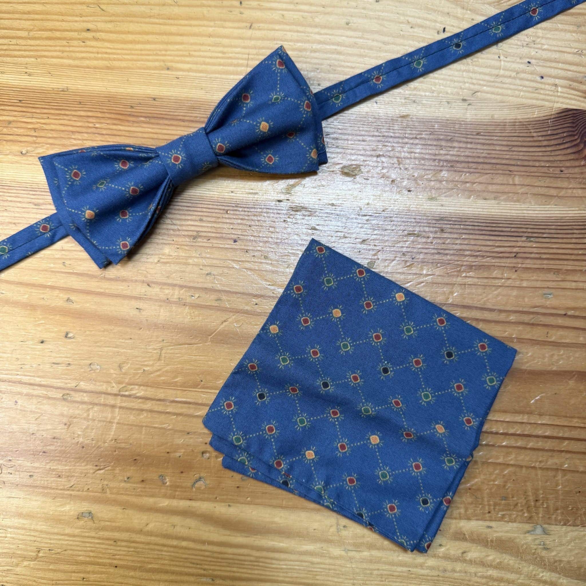 Corbata de charol azul con estampado de puntos y nudos.