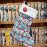 1. Medias navideñas de Ariel de La Sirenita con borde de felpa blanca y adorno de copo de nieve rojo.
