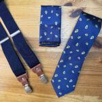 Corbata azul con estampado de avellanas, pañuelo a juego y tirantes para hombre elegante y sofisticado.