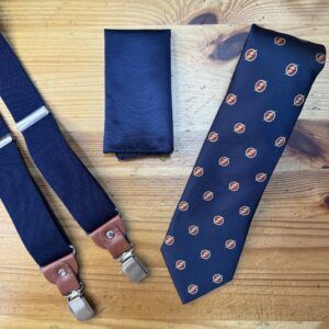 Corbata azul con patrón y tirantes en tonos navy y marrón, accesorios de elegancia masculina.