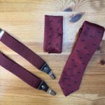 Corbata y tirantes burdeos con estampado de bigote negro, accesorios de vestir elegantes y modernas.