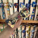 Cinta de diadema con diseño de arte y personajes icónicos de cultura pop. Perfecta para un estilo único y llamativo.