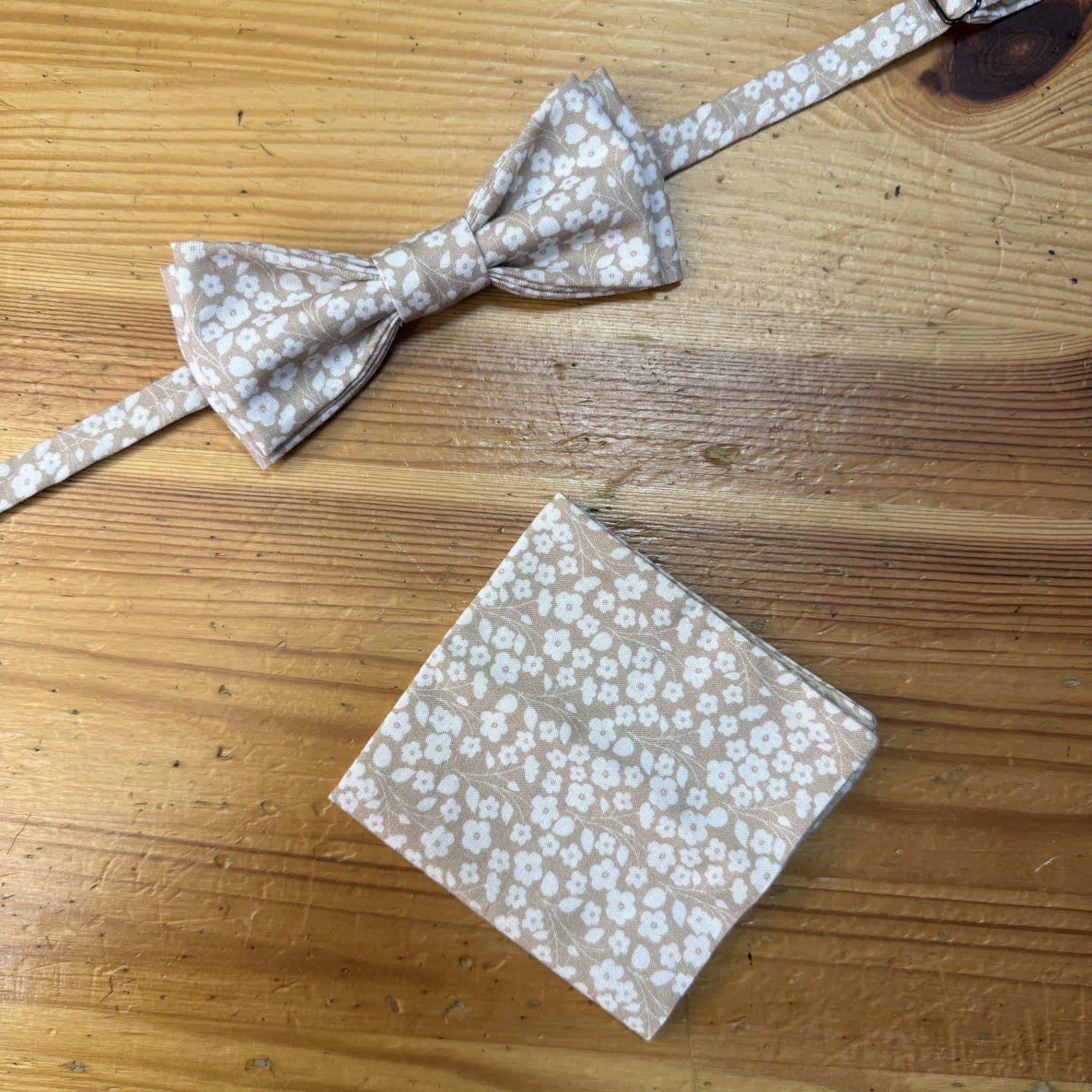Blandiblue de tela con estampado de flores blancas sobre fondo beige.
