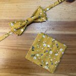 Accesoríos de moda - Corbatín y pañuelo de tela con estampado floral amarillo.