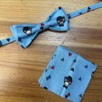 Corbatín y pañuelo con diseño de osito y triángulos en azul para bebé y niño pequeño.