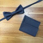 Corbatín y pañuelo elegantes en tela azul con pequeños puntos blancos para ocasiones formales.
