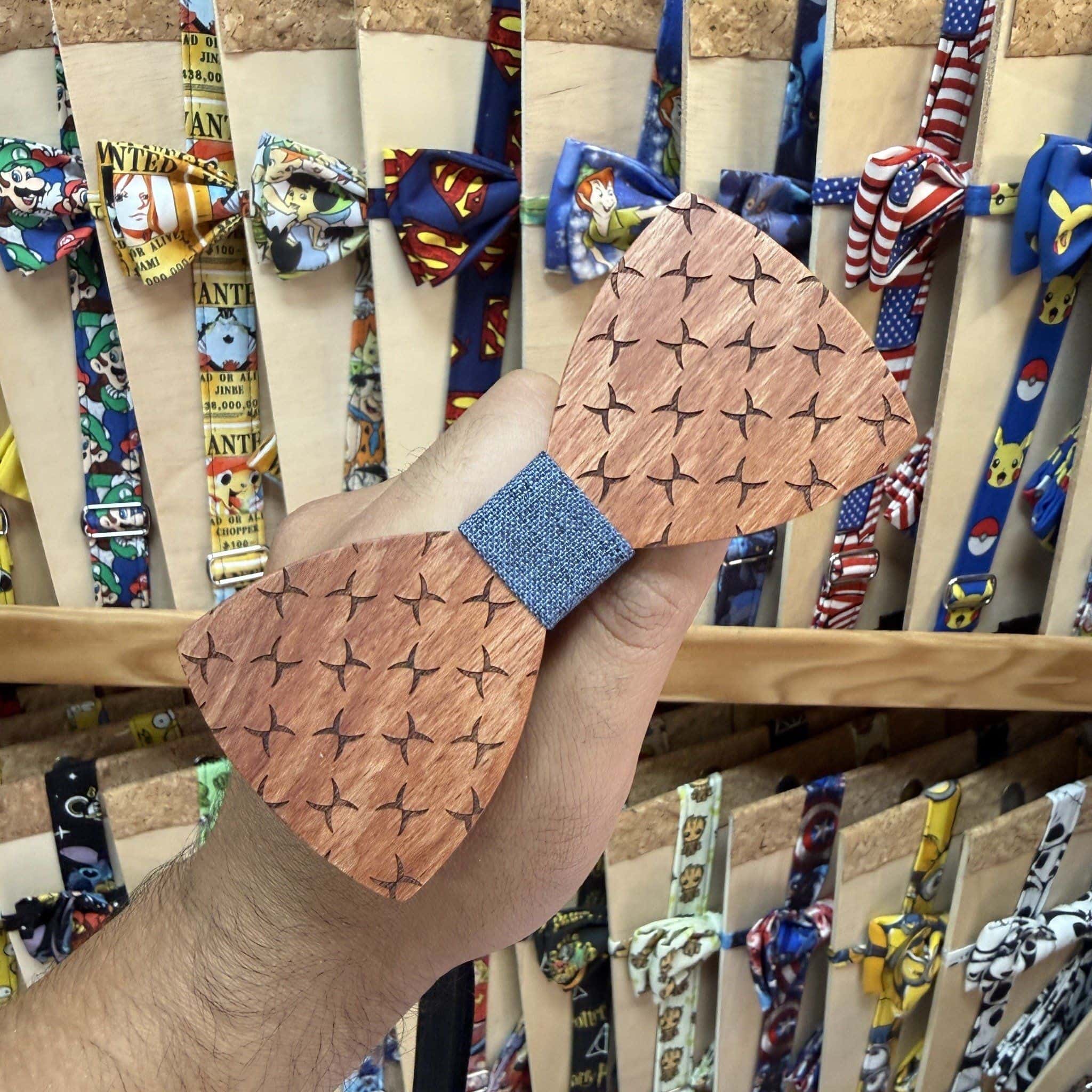 Dije de madera con estampado de cruces y banda de tela en el centro, estilo artesano y único.