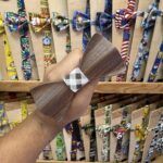 Colgante de madera con lazo de tela a cuadros en tienda de accesorios de moda infantiles y para mascotas.