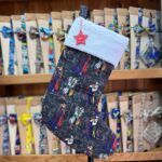 Calcetín navideño con diseño de personajes Disney, acabado en fieltro blanco y adorno de estrella roja.