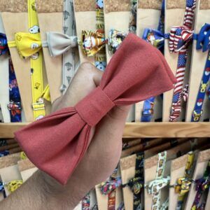 Lazada de papelería en color coral con lazo para mascotas o accesorios de moda; variedad de diseños en el fondo.