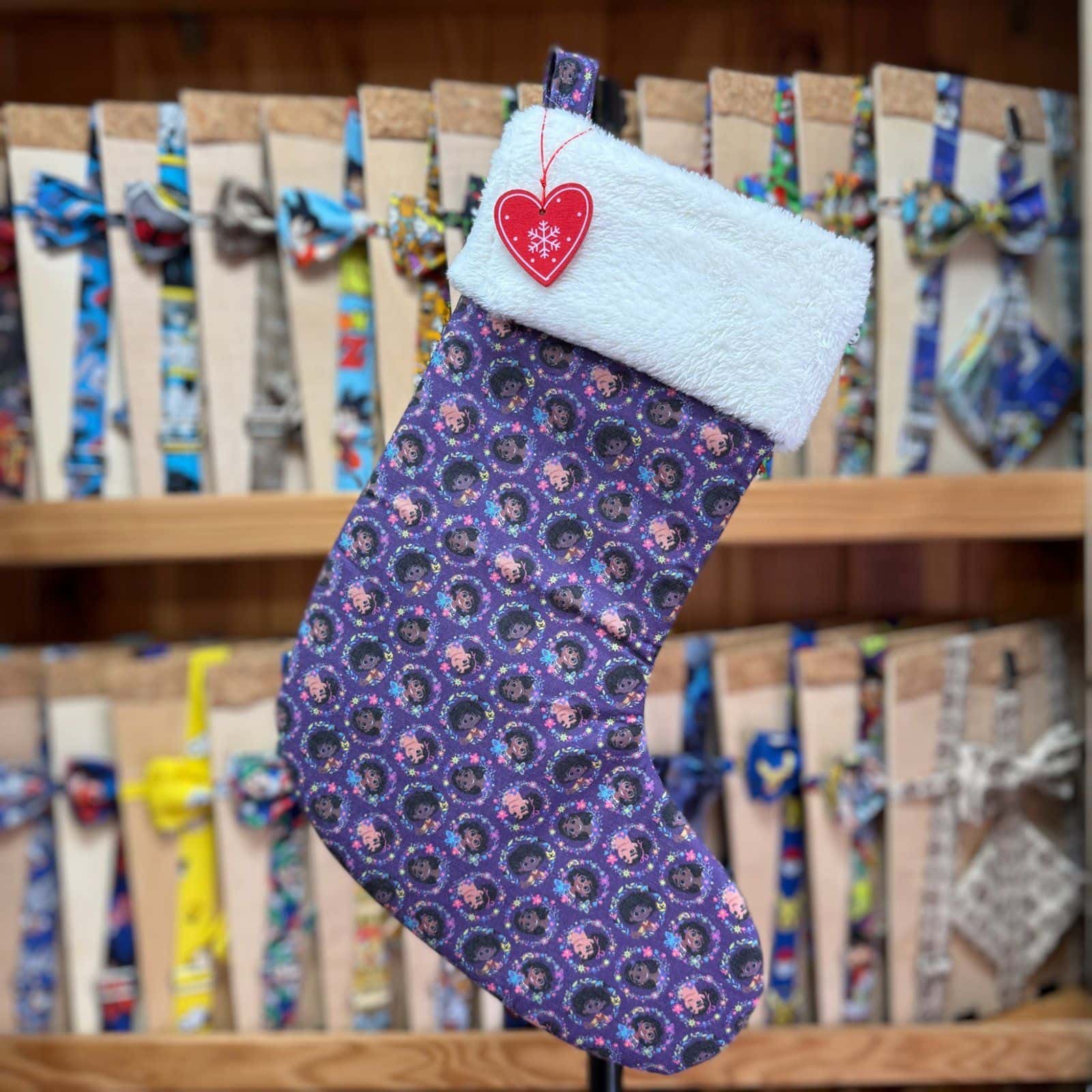Botín navideño de lana con diseño de personajes infantiles y punta de pelo blanco, perfecto para la temporada navideña.