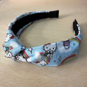 Colorido diadema con diseño de Hello Kitty, arcoíris y nubes, perfecto para accesorios infantiles y moda.