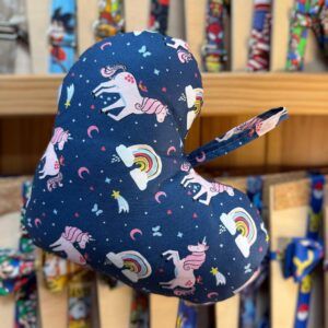 Colorido guante infantil con diseños de unicornios, arcoíris y nubes en fondo azul oscuro.