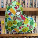 Colorida mochila infantil con personajes y naturaleza, ideal para niños y niñas. Diseño divertido y resistente.