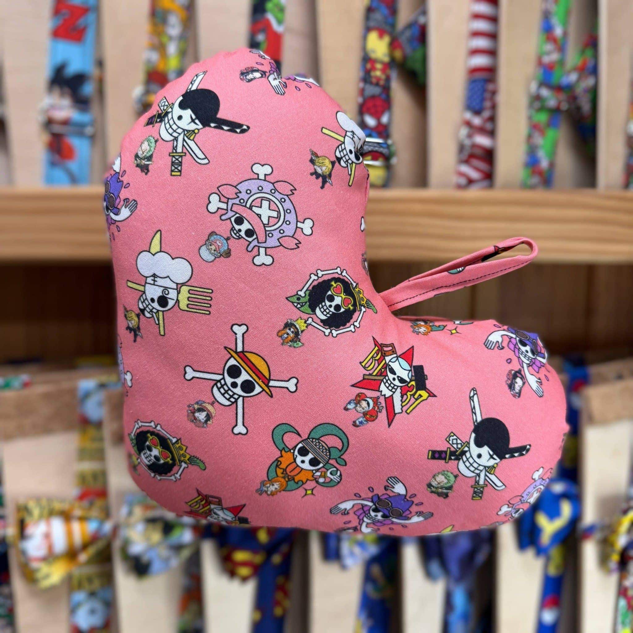 Colorido guante de cocina con diseño de calaveras y personajes de dibujos animados en fondo rosa.
