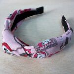 Tocado diadema con estampado de dibujos en tonos rosa y negro, accesorios de moda y complementos para mujer.
