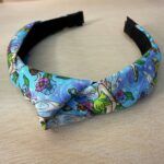 Varias cintas para la cabeza con estampado floral y de fantasía en tonos azules y verdes.