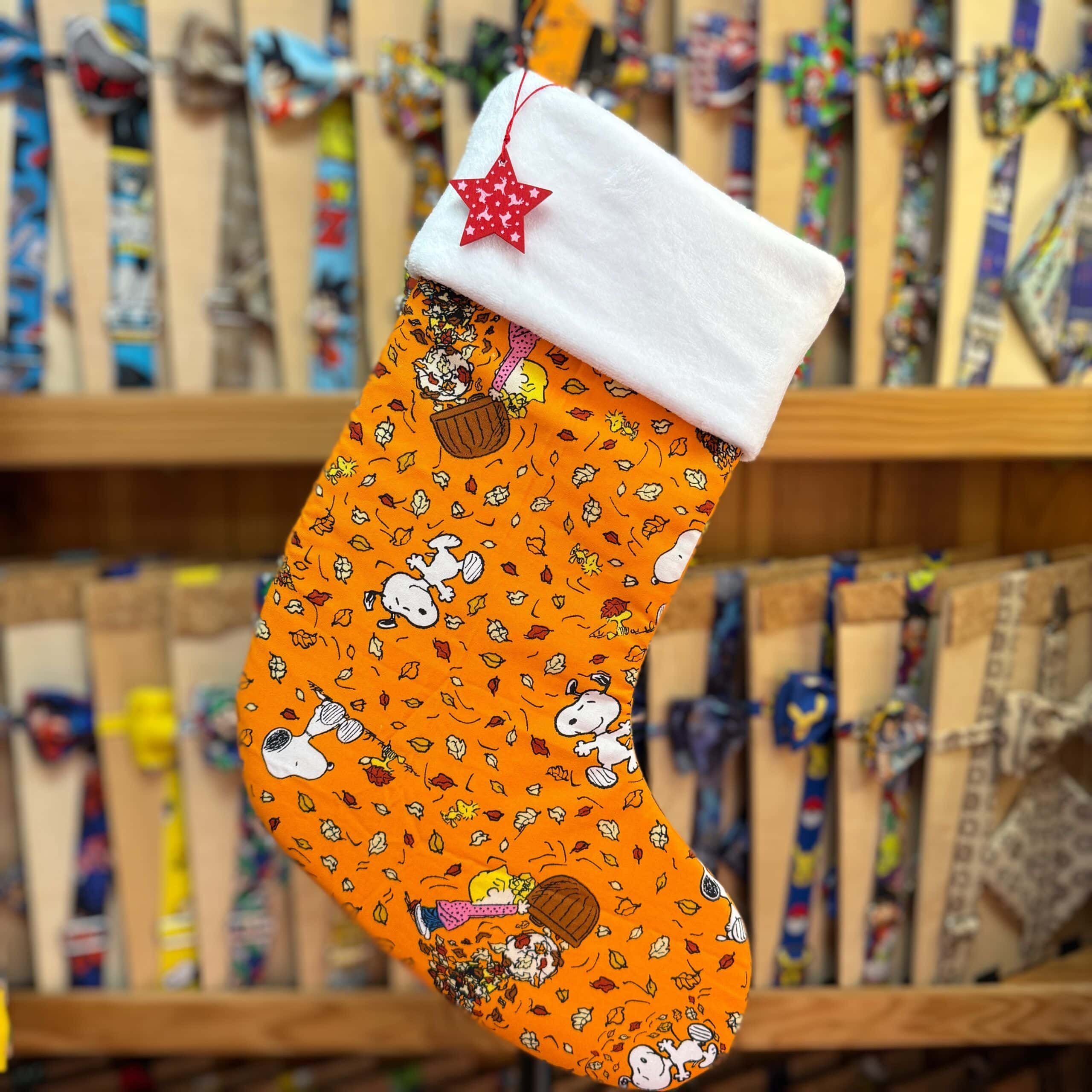 Cola de Navidad con diseño de Snoopy y amigos en color naranja. Ideal para decorar y regalar en fiestas navideñas.