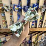 1. Diadema de lazo navideño con diseño de hojas de acebo y bolas blancas para eventos festivos.
