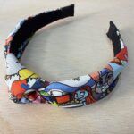 Arnés infantil de tela con diseño de personajes de dibujos animados, cómodo y ajustable.