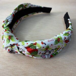 Diadema navideña con estampado de personajes y motivos festivos. Ideal para celebrar Navidad con estilo y alegría.