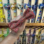 Colorido lazo de tela con estampado navideño y detalles dorados.