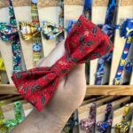 Dejada de la mano con lazo navideño de tela con diseño de acebo y bayas.
